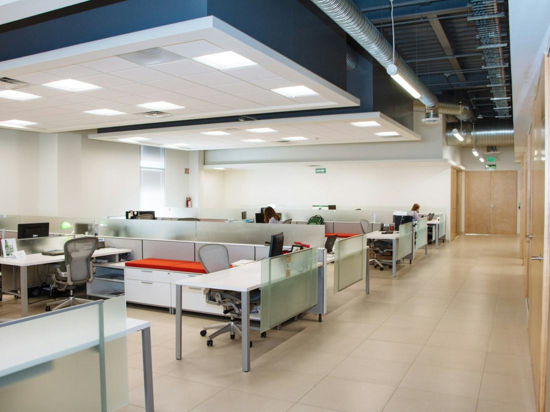 A clean open-plan office with white desks